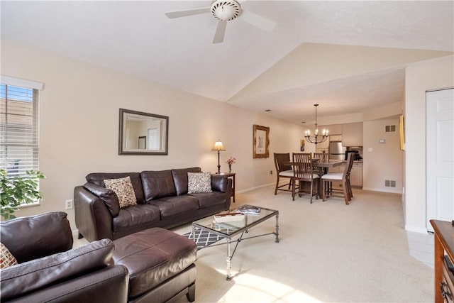 carpeted living room featuring ceiling fan with notable chandelier and lofted ceiling