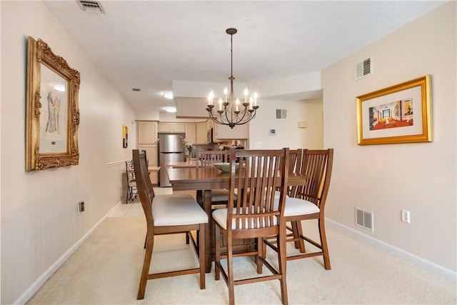 dining space with light colored carpet and a notable chandelier