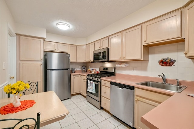 kitchen featuring light brown cabinetry, sink, and stainless steel appliances