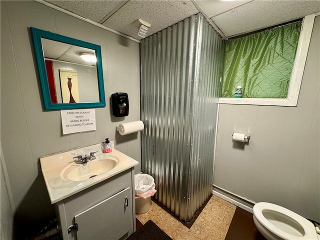 bathroom featuring a paneled ceiling, vanity, and toilet