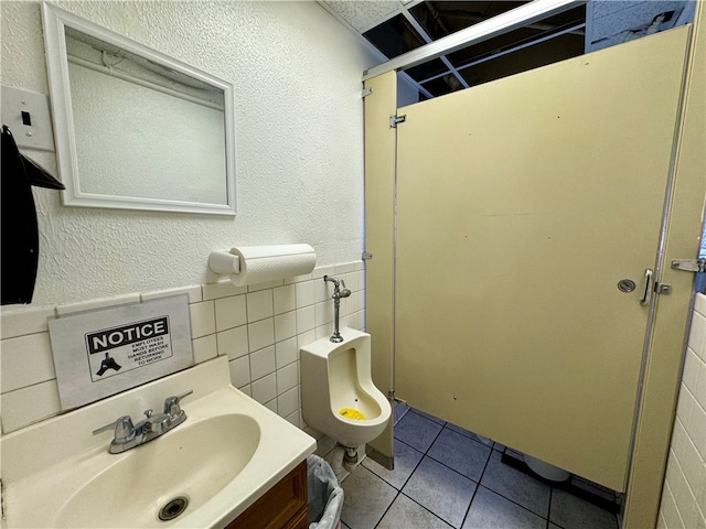 bathroom with tile patterned floors, vanity, tile walls, and toilet