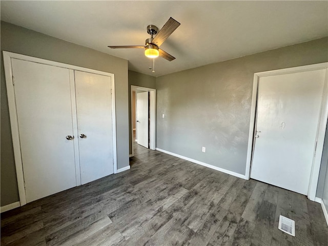 unfurnished bedroom with ceiling fan, dark hardwood / wood-style flooring, and a closet