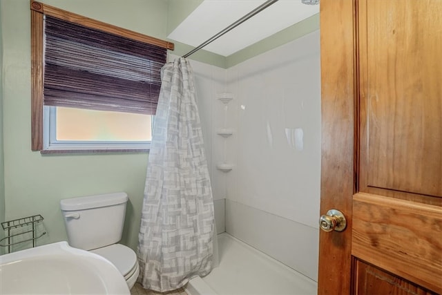 bathroom with a shower with shower curtain and toilet