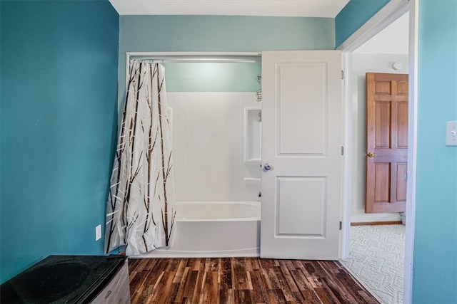 bathroom with hardwood / wood-style floors, vanity, and shower / tub combo with curtain