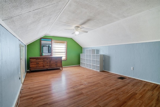 bonus room featuring vaulted ceiling, ceiling fan, a textured ceiling, and hardwood / wood-style flooring