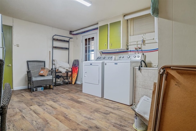 laundry room featuring washing machine and dryer and light hardwood / wood-style floors