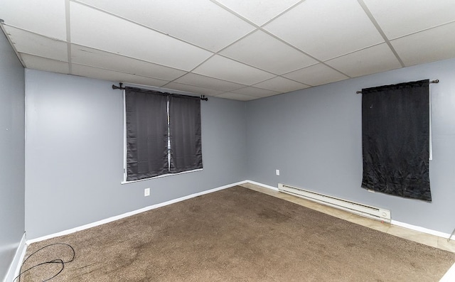 unfurnished room with carpet, a paneled ceiling, and baseboard heating