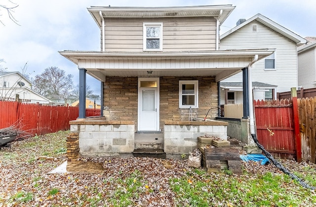 rear view of property featuring covered porch