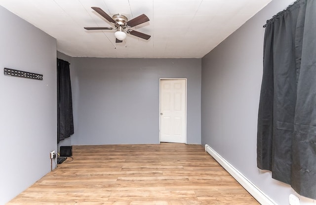 unfurnished room with baseboard heating, ceiling fan, and light wood-type flooring