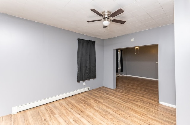 spare room featuring ceiling fan, light wood-type flooring, and a baseboard radiator