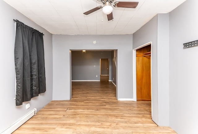 corridor with light wood-type flooring and baseboard heating