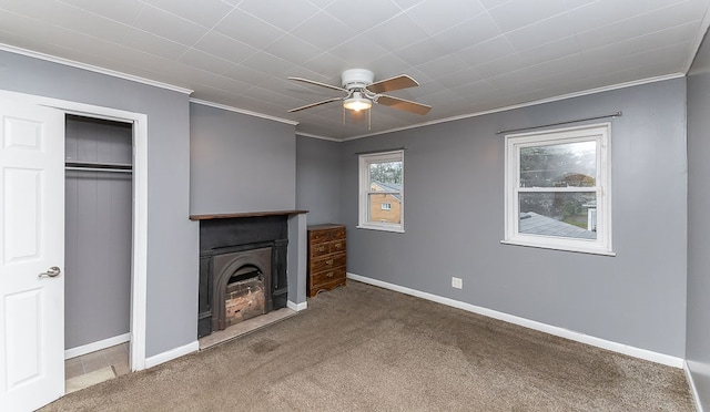 unfurnished living room with ceiling fan, carpet, and ornamental molding