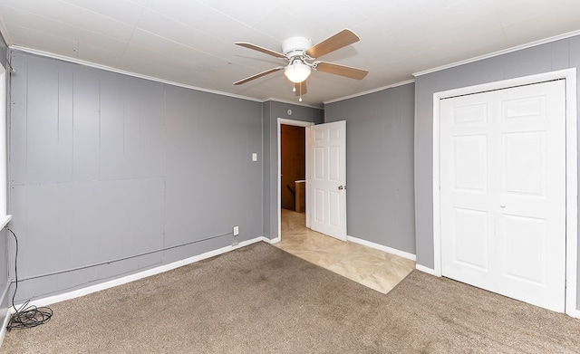 unfurnished bedroom featuring ceiling fan, a closet, carpet, and ornamental molding