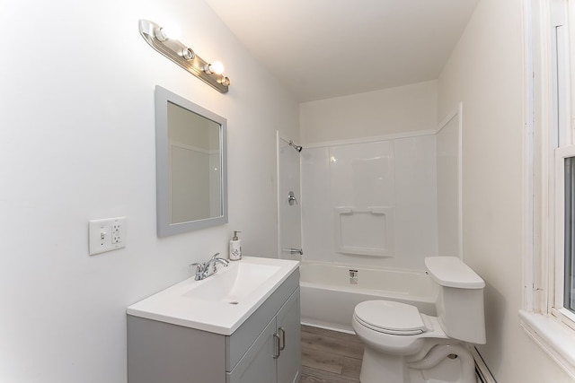 full bathroom with hardwood / wood-style floors, vanity, a baseboard heating unit, toilet, and tub / shower combination