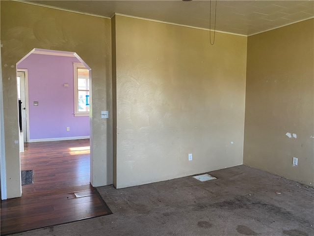 empty room with crown molding and dark wood-type flooring