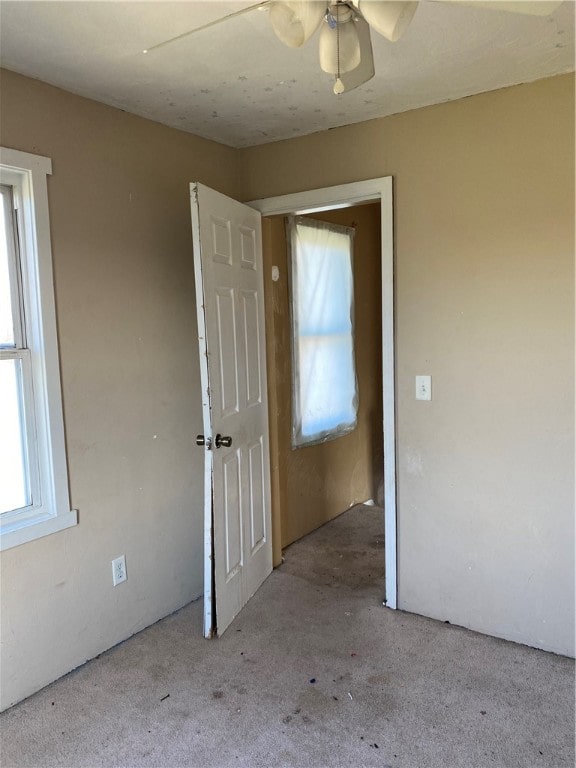 interior space featuring light colored carpet and ceiling fan