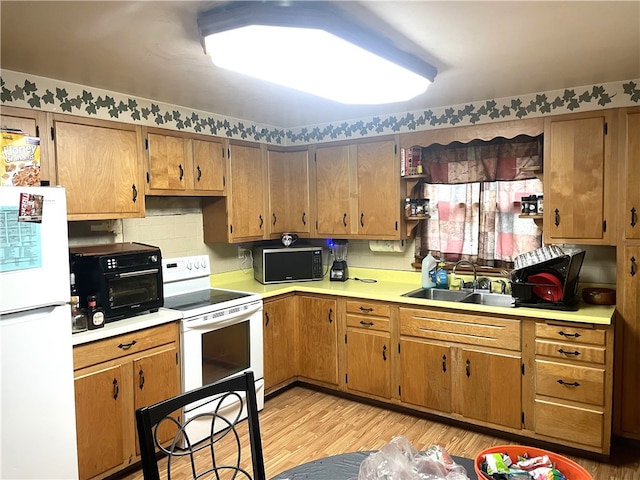 kitchen featuring decorative backsplash, sink, light hardwood / wood-style floors, and white appliances