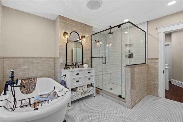 bathroom with vanity, shower with separate bathtub, wood-type flooring, and tile walls