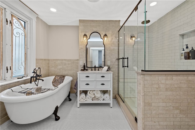 bathroom featuring tile patterned floors, vanity, plus walk in shower, and tile walls