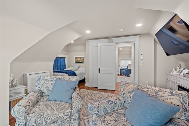 bedroom with hardwood / wood-style floors and lofted ceiling