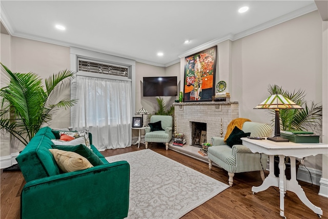 living room featuring hardwood / wood-style flooring, crown molding, and a fireplace