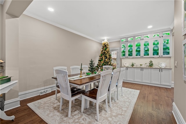 dining space with hardwood / wood-style flooring and ornamental molding