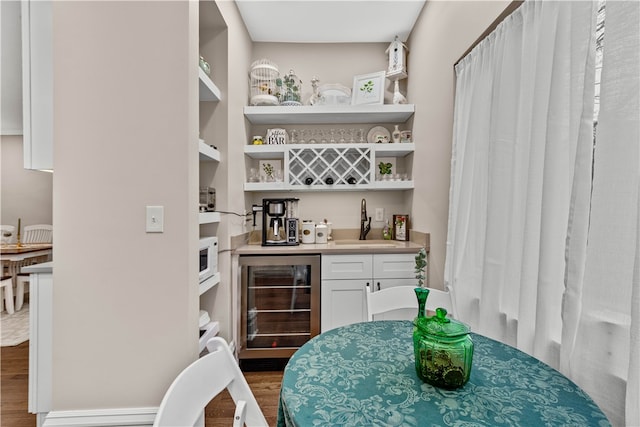 bar with white cabinets, dark hardwood / wood-style flooring, wine cooler, and sink