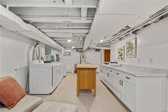 clothes washing area with washing machine and dryer and gas water heater