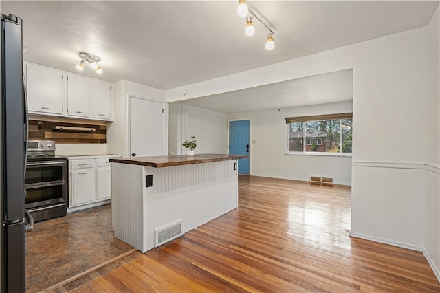 kitchen featuring dark hardwood / wood-style floors, a kitchen bar, white cabinetry, and stainless steel appliances