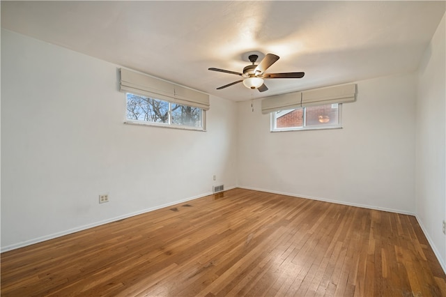 unfurnished room with a wealth of natural light, ceiling fan, and hardwood / wood-style flooring