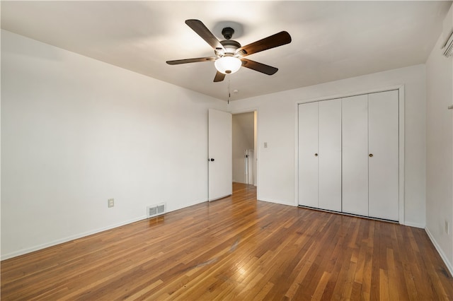 unfurnished bedroom with hardwood / wood-style floors, a closet, and ceiling fan