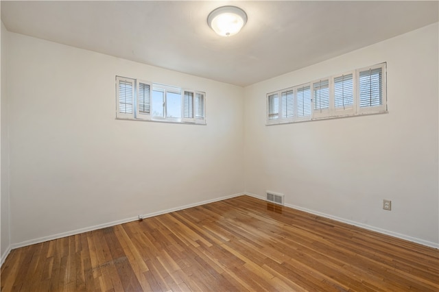 spare room with plenty of natural light and wood-type flooring