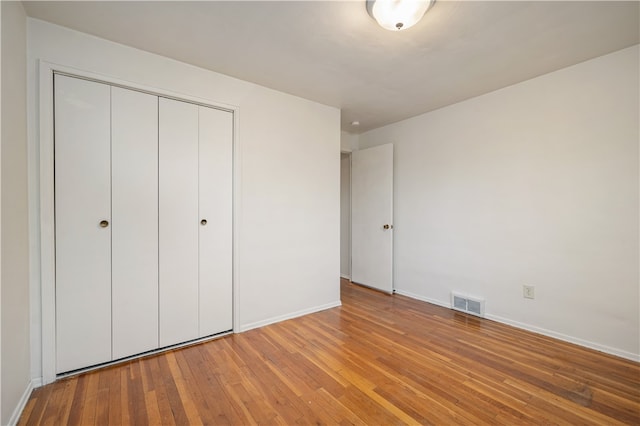 unfurnished bedroom featuring a closet and light hardwood / wood-style flooring