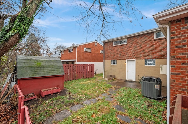 rear view of house with cooling unit and a shed