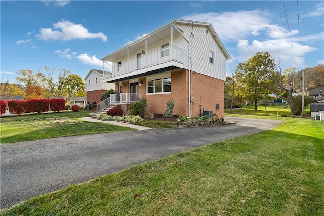 view of front of home with central AC, a porch, and a front yard