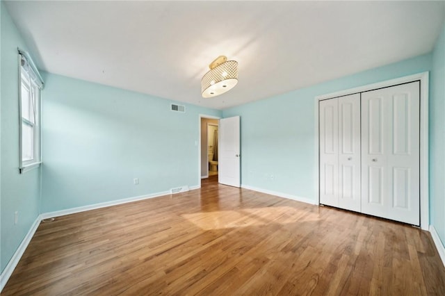 unfurnished bedroom featuring hardwood / wood-style flooring and a closet