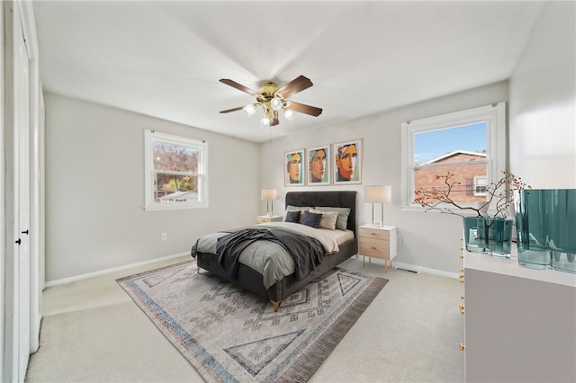 carpeted bedroom featuring ceiling fan and multiple windows