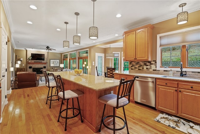 kitchen featuring ceiling fan, dishwasher, ornamental molding, decorative light fixtures, and light wood-type flooring