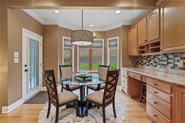 dining area with light hardwood / wood-style floors and ornamental molding