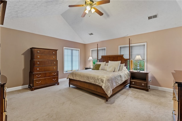 bedroom with a textured ceiling, ceiling fan, light colored carpet, and lofted ceiling