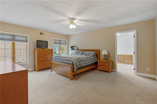 carpeted bedroom featuring a textured ceiling and ceiling fan