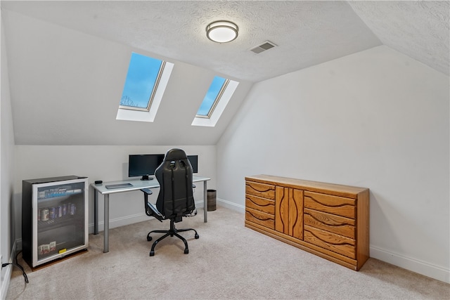 office featuring a textured ceiling, light colored carpet, and vaulted ceiling