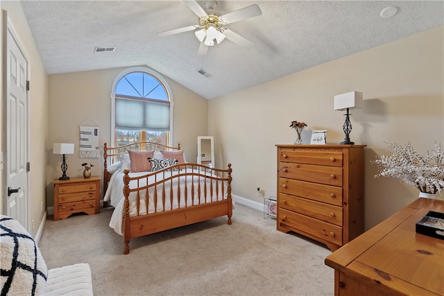 carpeted bedroom with a textured ceiling, ceiling fan, and vaulted ceiling