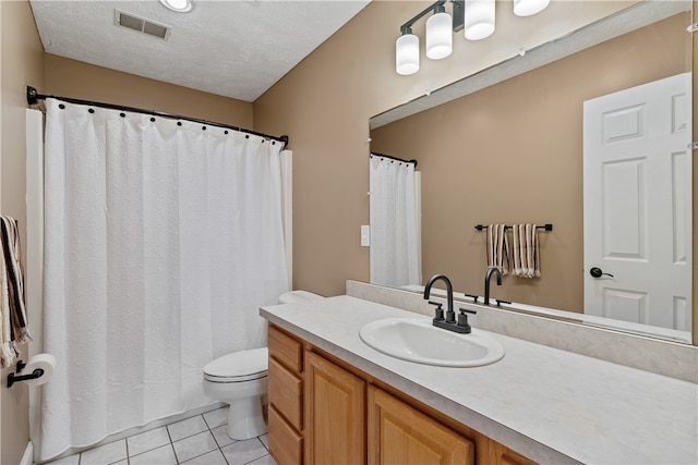 bathroom with tile patterned floors, vanity, toilet, and a textured ceiling