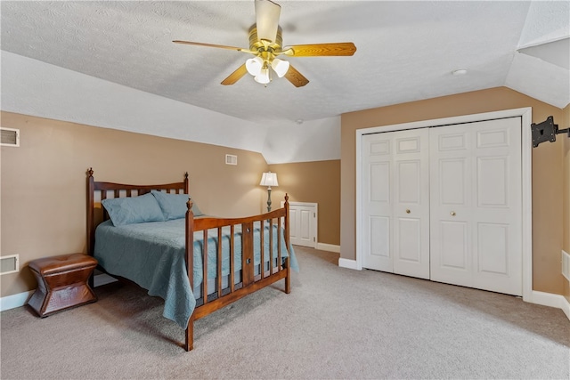 carpeted bedroom featuring a textured ceiling, ceiling fan, a closet, and vaulted ceiling