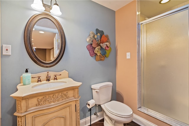 bathroom with vanity, toilet, and a shower with shower door