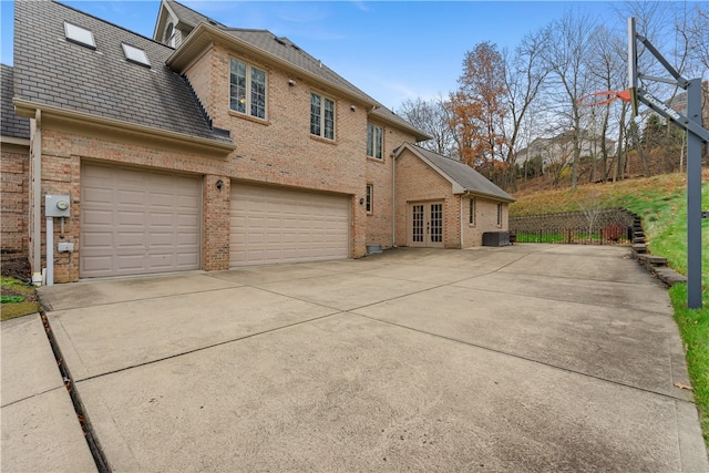 view of side of home featuring french doors and a garage