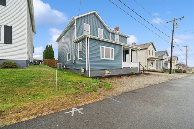 view of front of property with cooling unit and a front yard