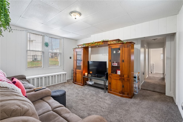 carpeted living room featuring a paneled ceiling and radiator