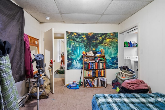 carpeted bedroom featuring a paneled ceiling, separate washer and dryer, and ensuite bathroom